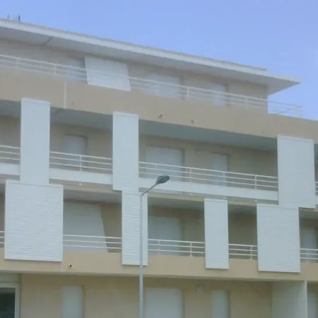 Immeuble résidentiel moderne équipé de volets coulissants blancs en façade, protection solaire et isolation pour appartements