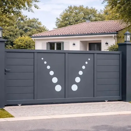 Portail coulissant en aluminium RAL 7016 intégré dans une clôture en pierre avec piliers aluminium, devant une petite villa
