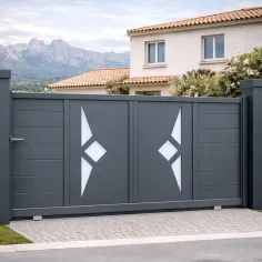 Portail coulissant en aluminium RAL 7016 avec piliers assortis, installé devant une maison à Calvi
