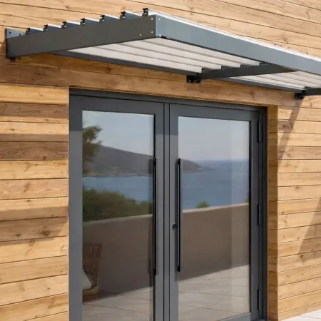 Marquise auvent en aluminium à lames fixes installée au-dessus d’une porte d’entrée vitrée à deux battants sur façade de bois