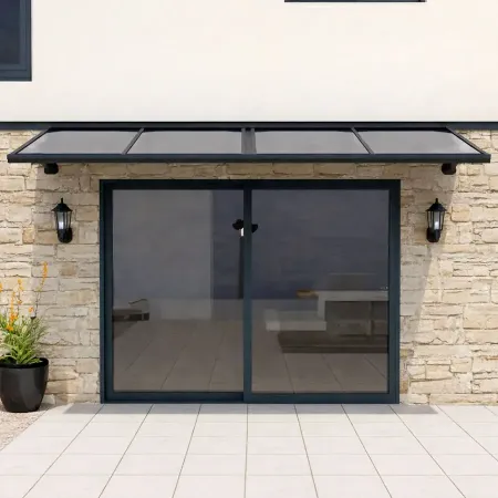 Auvent en aluminium à panneaux fixes installé au-dessus d’une baie vitrée sur façade en pierre