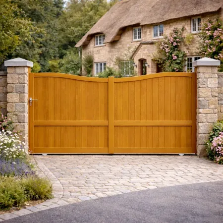 Portail coulissant en aluminium finition chêne doré avec piliers en pierre assortis, installé devant une maison contemporaine .