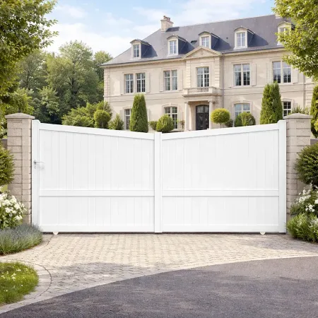 Portail coulissant en aluminium RAL 9010 installé devant une grande maison bourgeoise avec jardin paysager et allée pavée.