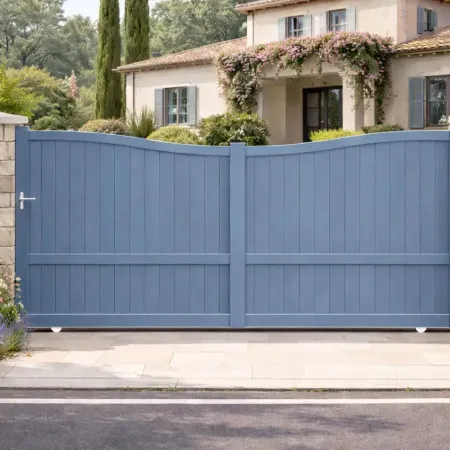 Portail coulissant en aluminium RAL 5014 bleu pigeon installé devant une maison méditerranéenne, avec piliers en pierre.