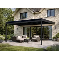 Pergola solaire adossée en aluminium noir installée devant une maison en pierre avec grande baie vitrée