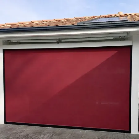 Store vertical ZIP bordeaux installé sur terrasse extérieure de maison avec coffre apparent