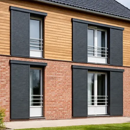 Volets coulissants en aluminium RAL 7016 gris anthracite installés sur une façade en brique et bardage bois.
