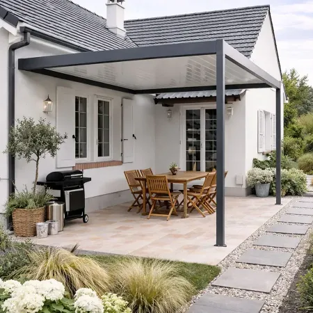 Pergola aluminium adossée protégeant un espace repas sur terrasse de maison contemporaine avec jardin paysager