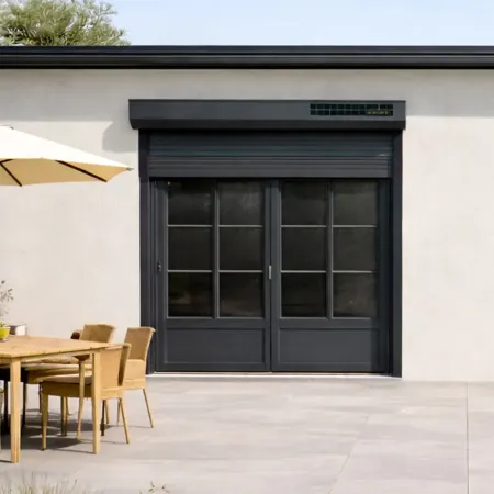 Volets roulants solaires RAL 7016 sur baies vitrées d’une maison moderne, vue de face avec terrasse extérieure aménagée