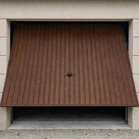 Porte de garage basculante en bois foncé sur façade en crépi moderne avec sol en bitume, vue extérieure
