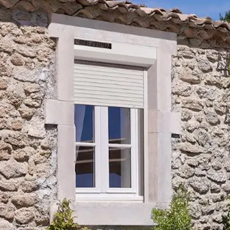 Volet roulant solaire installé sur façade de maison moderne avec vue extérieure complète et jardin