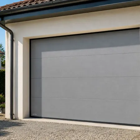 Porte de garage sectionnelle gris aluminium RAL 9007 sur façade de maison contemporaine avec extérieur aménagé