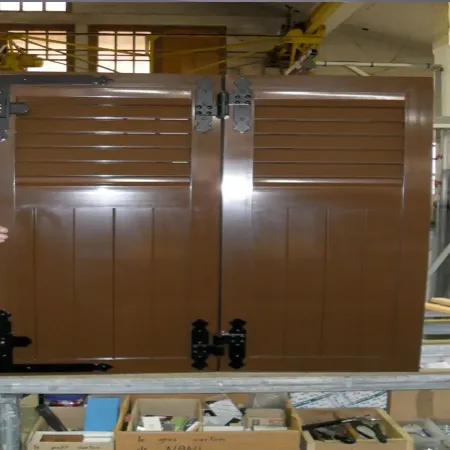 Volet battant aluminium persienné brun sur mesure avec lames ajourées, conçu pour offrir ventilation, sécurité et durabilité.