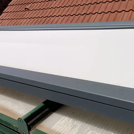 Coffre de volet roulant aluminium sur mesure gris anthracite avec tablier intégré, installé sur une maison individuelle.