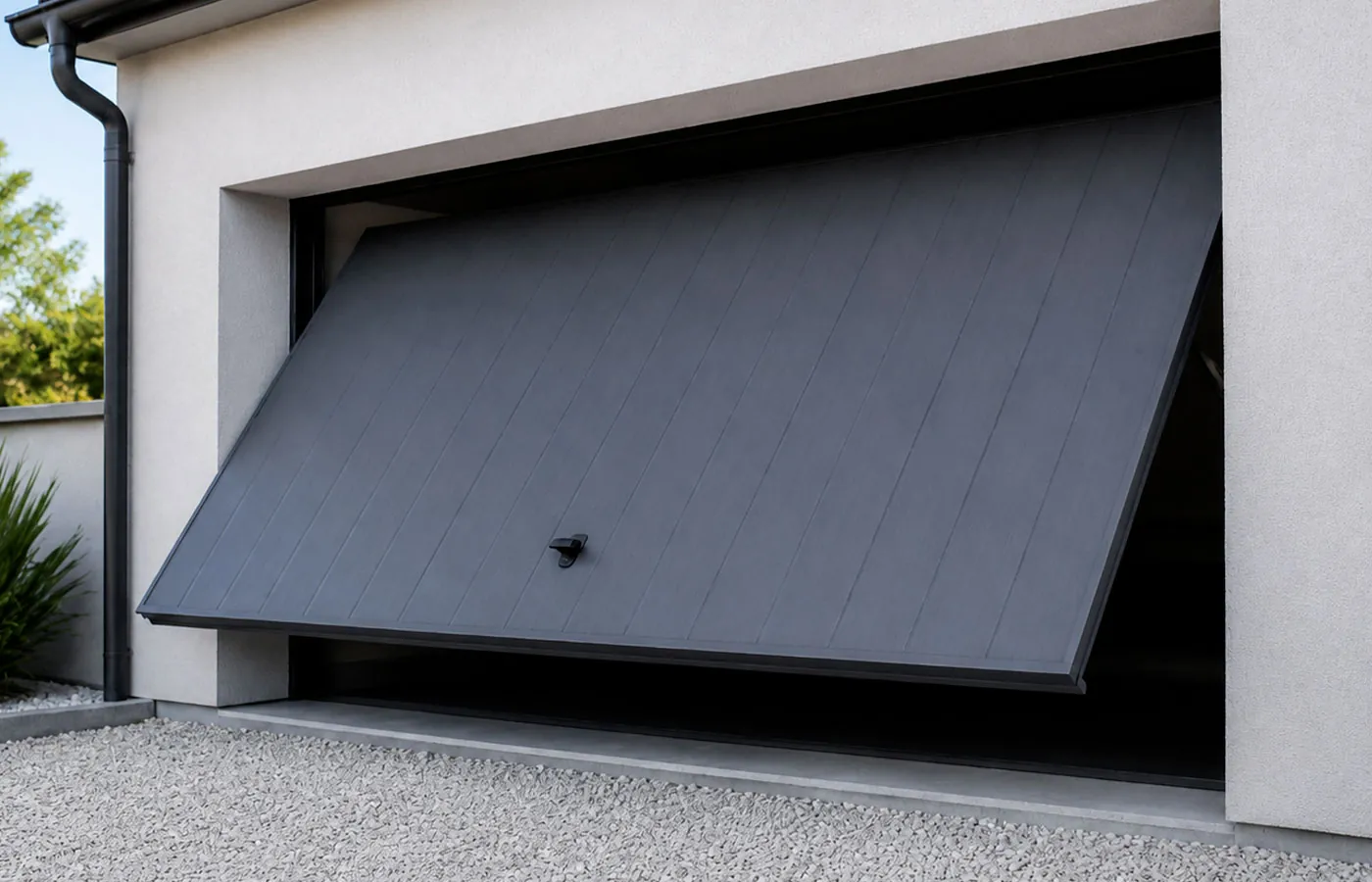 Porte de garage basculante anthracite en acier avec ouverture d&eacute;bordante, design moderne et finition &eacute;l&eacute;gante pour maison contemporaine.