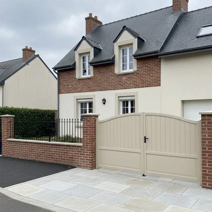 Portail aluminium ADRI beige devant une maison en brique