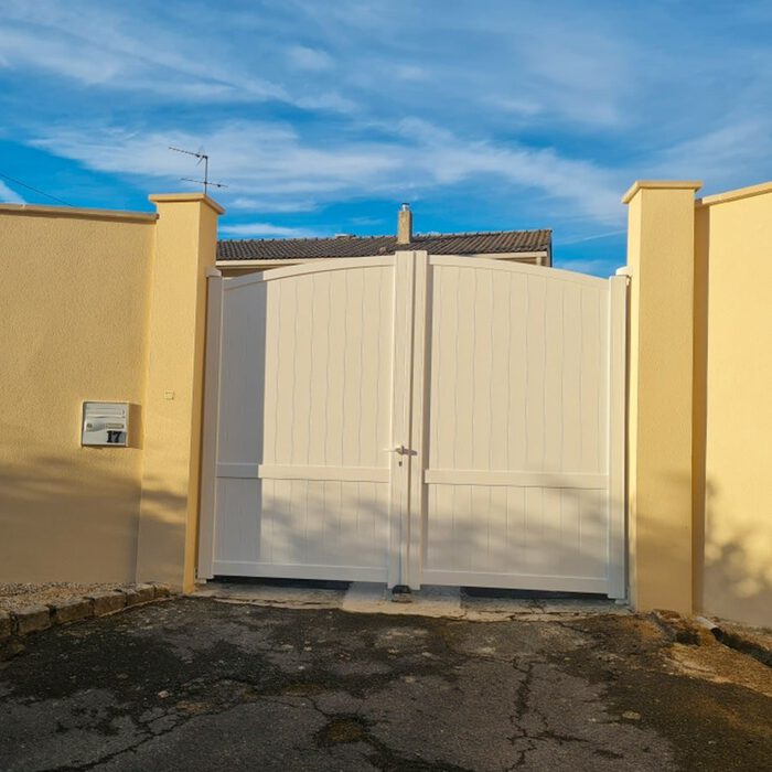 Portail aluminium ADRI blanc cassé entre deux murs colorés