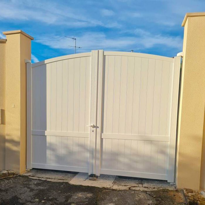 Portail aluminium ADRI ivoire entre deux murs ocre