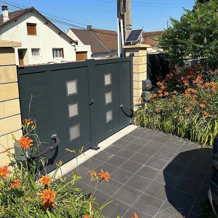 Portail aluminium ARSE gris anthracite devant un jardin fleuri