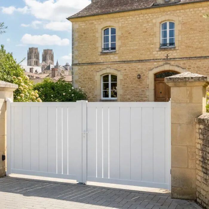 Portail aluminium BAFFIN blanc devant une maison en pierre