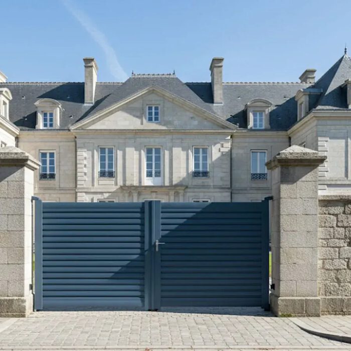 Portail aluminium BAGO bleu nuit devant une demeure classique