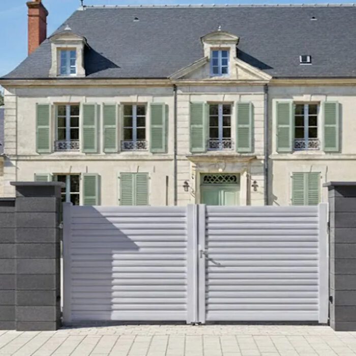 Portail aluminium BAGO gris devant une maison à volets