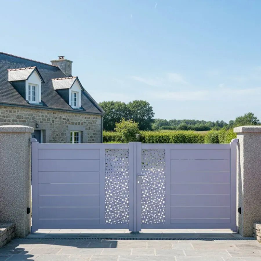 Portail aluminium BARBUDA gris lilas entre deux piliers, devant une maison normande