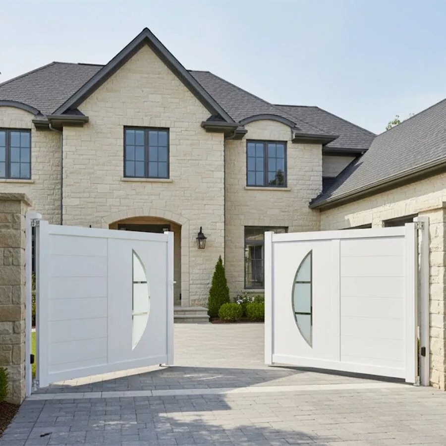 Portail aluminium BYL blanc, les deux vantaux ouverts devant une maison en pierre claire