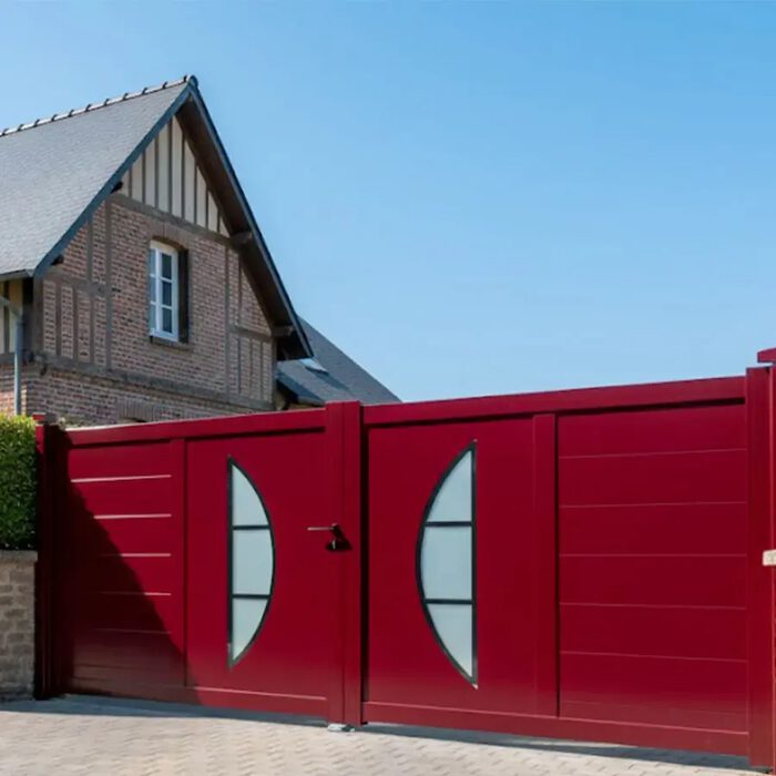 Portail aluminium BYL rouge devant une maison normande