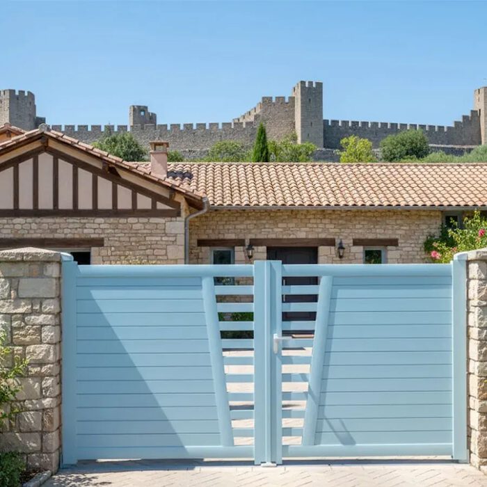 Portail aluminium COLN bleu clair devant une maison de village