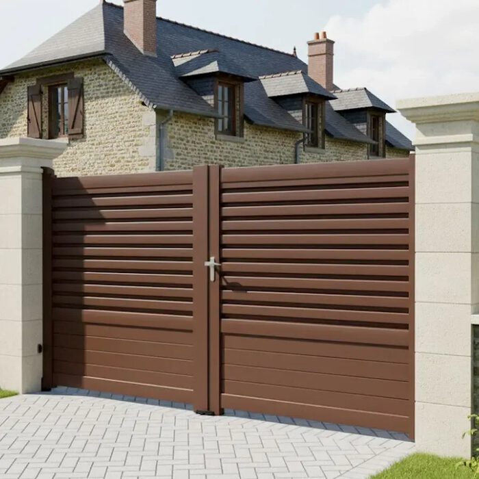 Portail aluminium DAD brun devant une maison en pierre