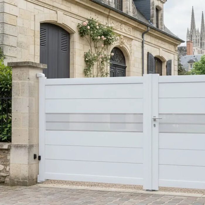 Portail aluminium DEVON blanc devant une maison en pierre