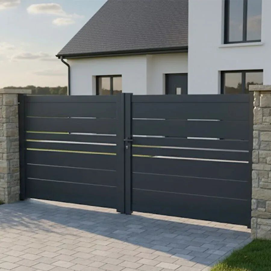 Portail aluminium DEVON gris anthracite entre deux piliers, sur une allée pavée