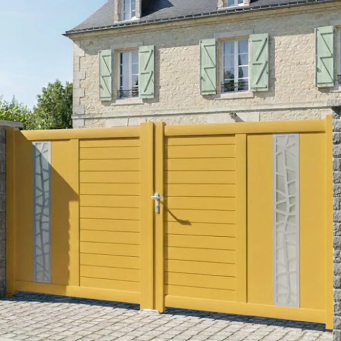 Portail aluminium JAM jaune devant une maison ancienne