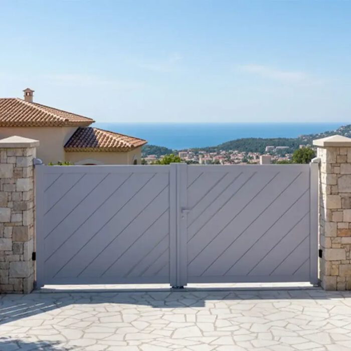 Portail aluminium LESM gris lilas entre deux piliers en pierre