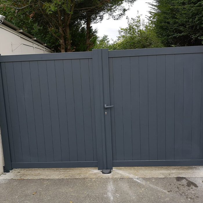 Portail aluminium NATI gris anthracite sur une allée bordée d'arbres