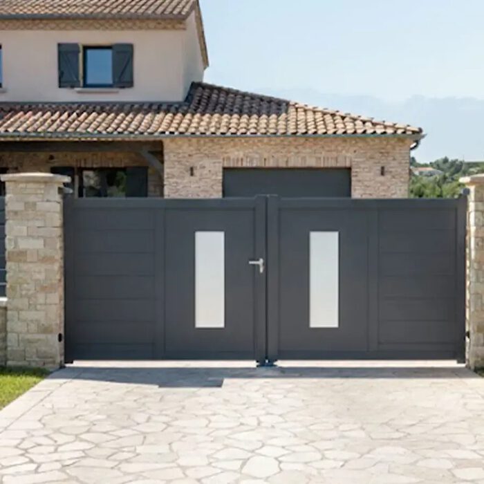 Portail aluminium ORC gris anthracite sur une allée en pierre