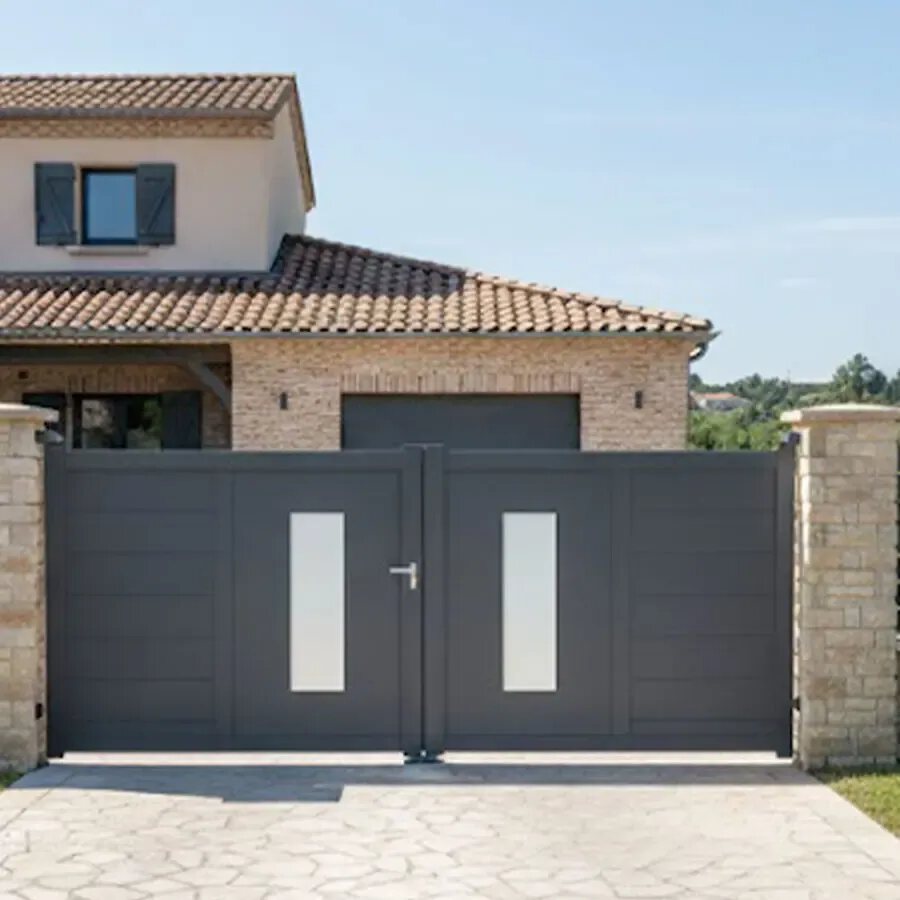 Portail aluminium design ORC gris anthracite entre deux piliers, devant une maison contemporaine