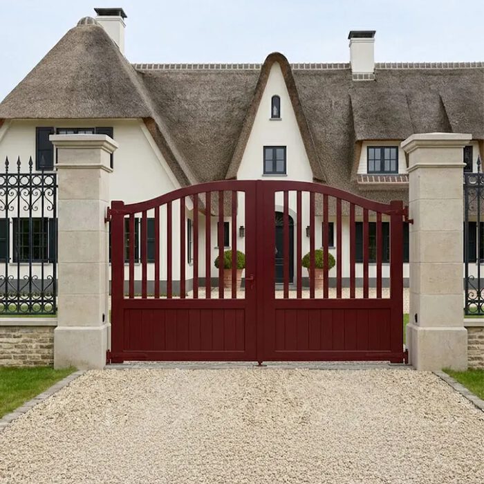 Portail aluminium PIL bordeaux devant une chaumière