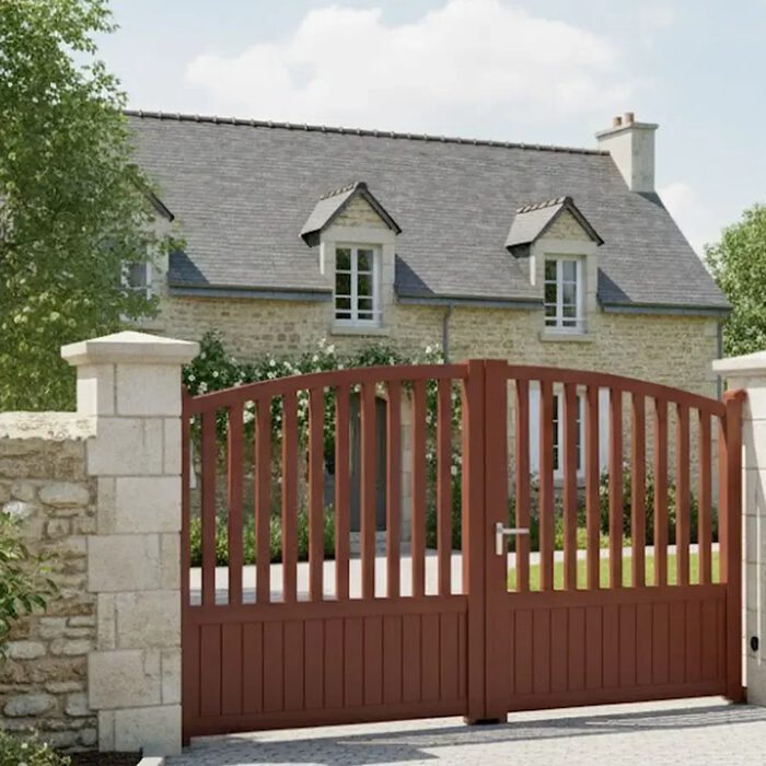 Portail aluminium PIL rouge brique devant une maison en pierre