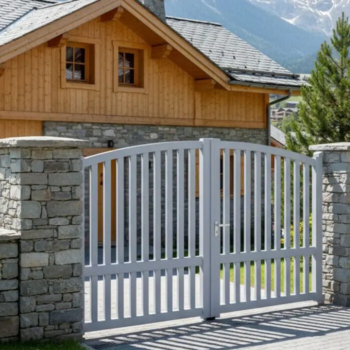 Portail aluminium ROC blanc devant un chalet en bois
