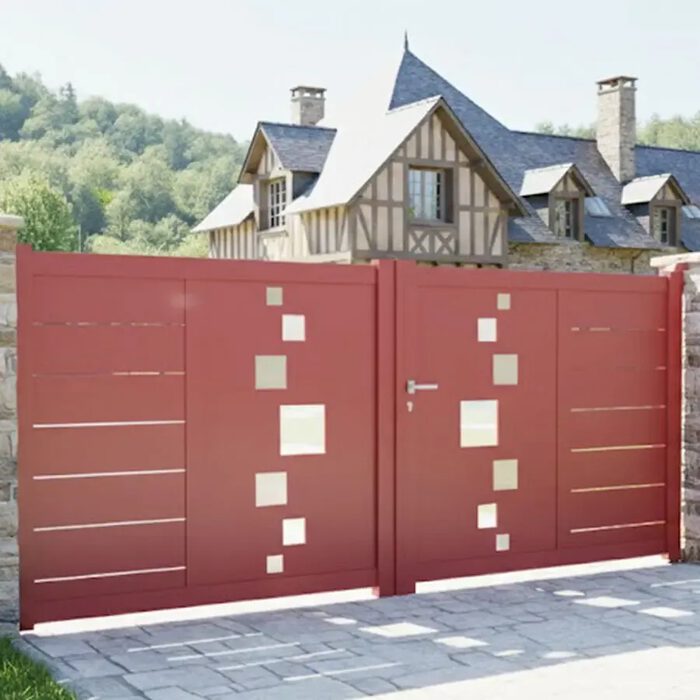 Portail aluminium SOM rouge devant une maison à colombages
