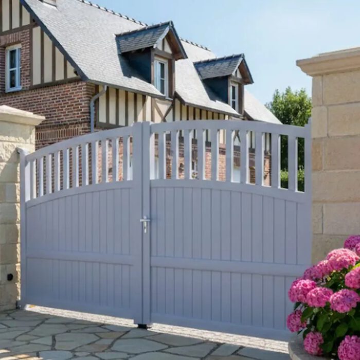 Portail aluminium TOM bleu gris devant une maison à colombages