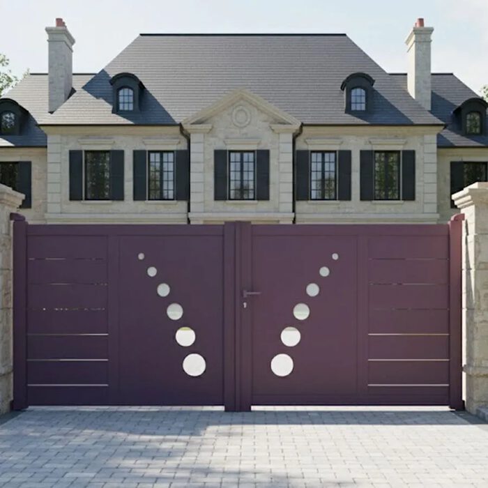 Portail aluminium TRAI prune devant une maison en pierre de taille