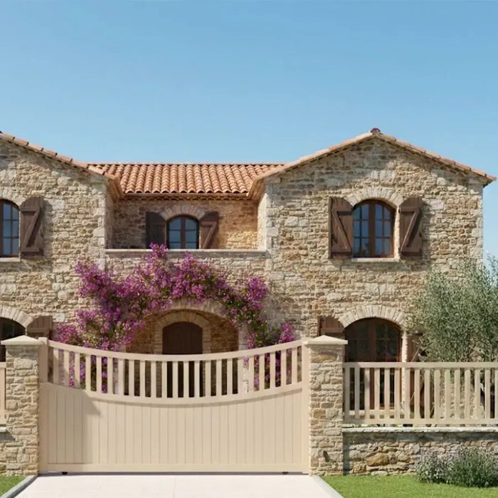 Portail coulissant BEN beige devant une maison en pierre