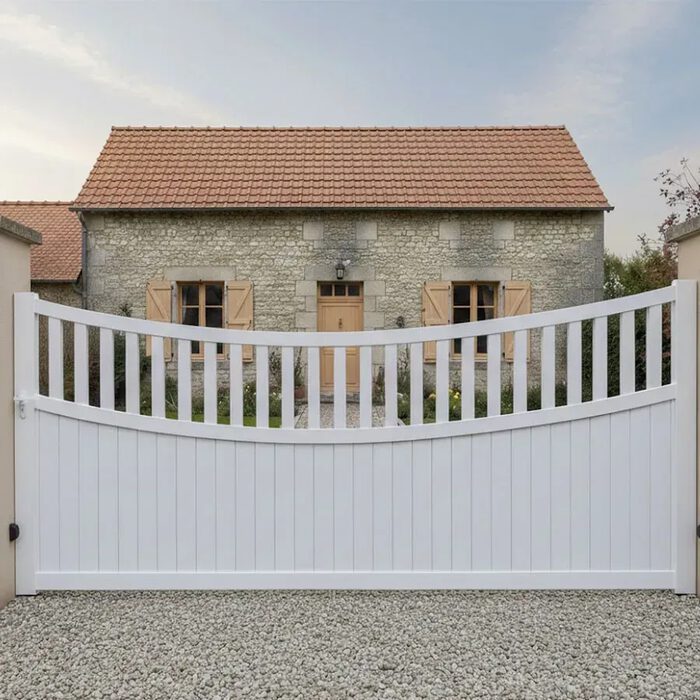 Portail coulissant BEN blanc devant une maison en pierre