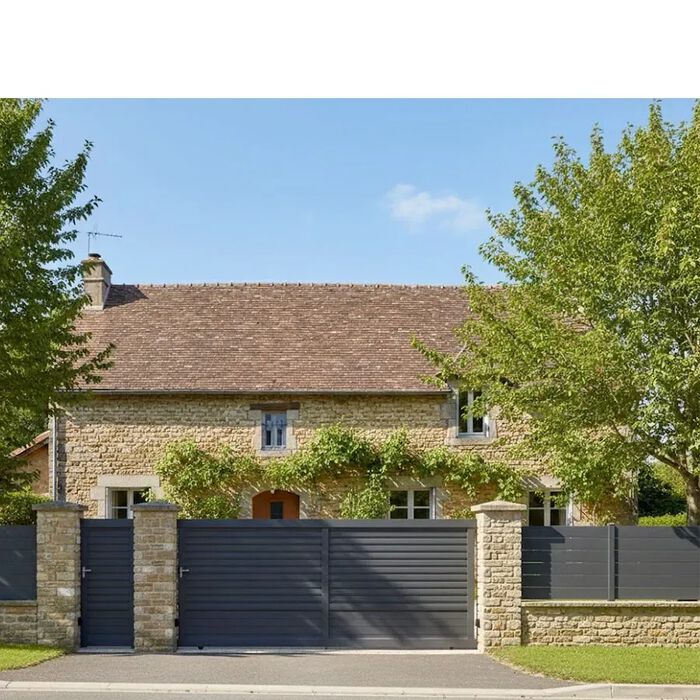 Portail coulissant DAD gris anthracite devant une longère en pierre