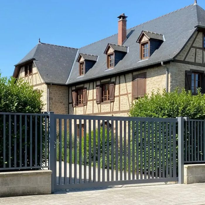 Portail coulissant DEN gris anthracite devant une maison normande