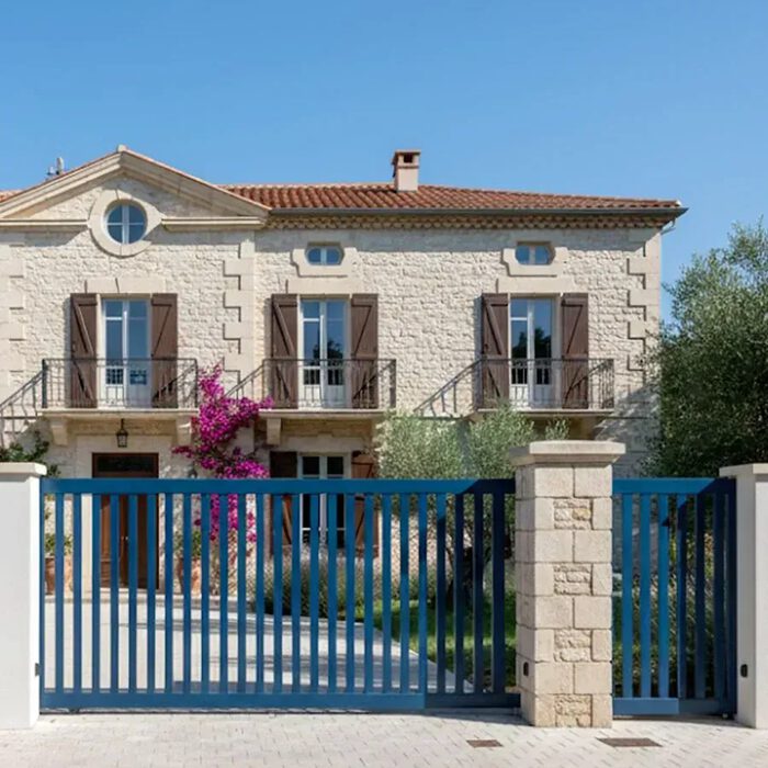 Portail coulissant DEN bleu devant une bastide