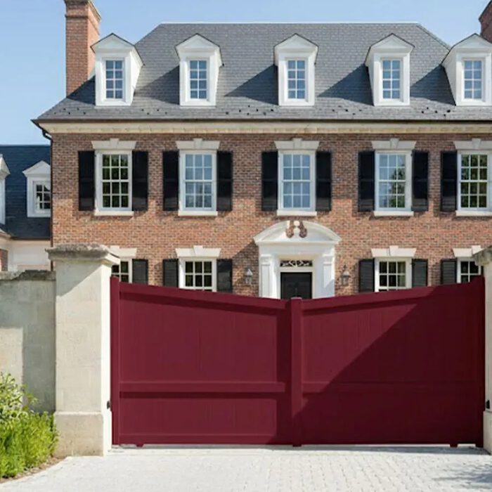 Portail coulissant ROSE bordeaux devant une maison en briques